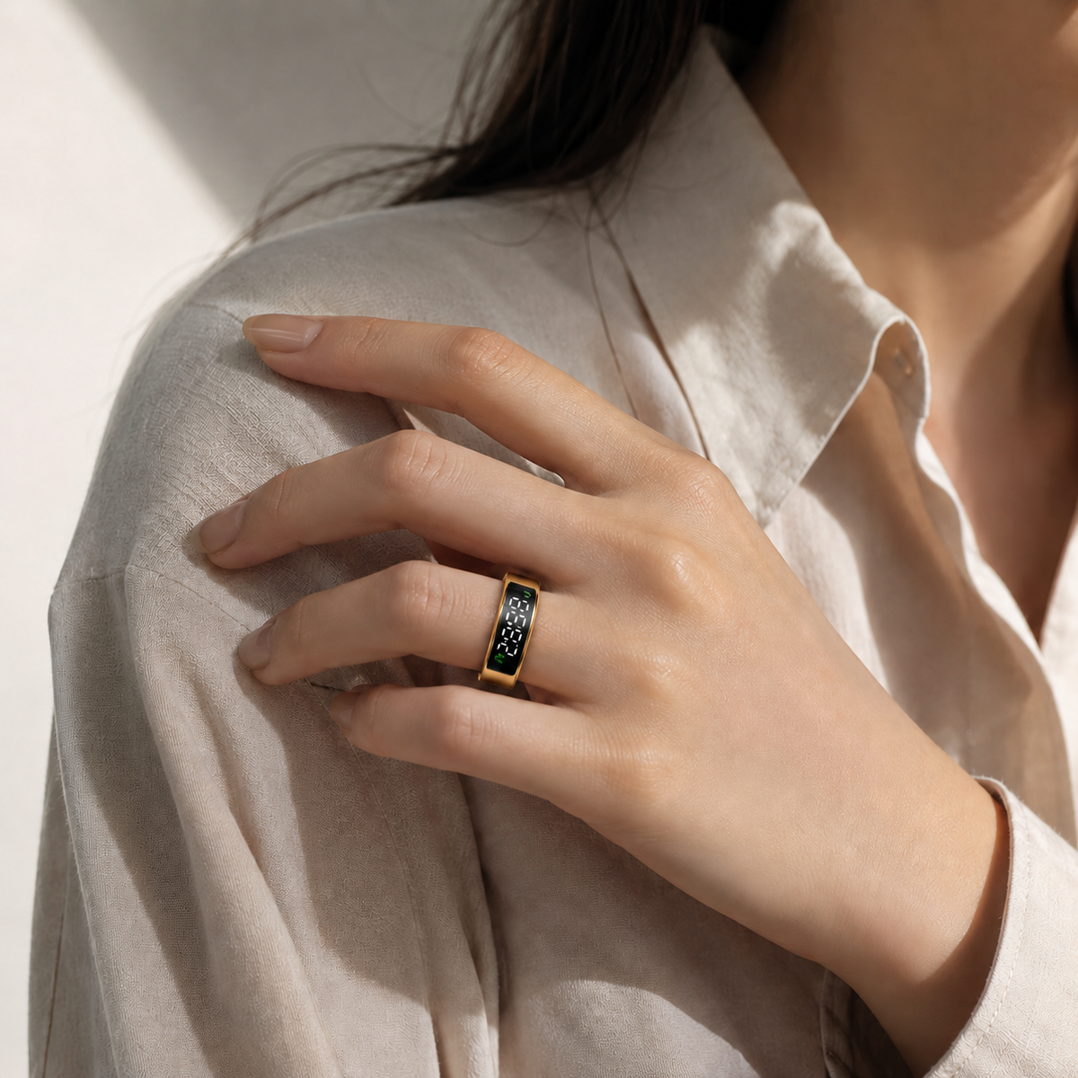 Woman wearing a gold SY1 LED smart ring with a white blouse in warm sunlight#color_gold