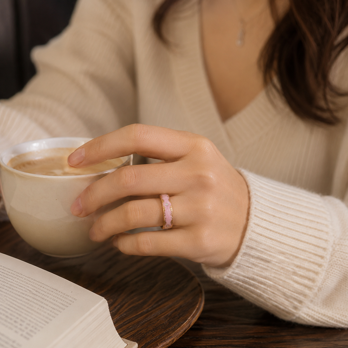 Woman wearing a Retro Pink Smart Ring while holding a coffee cup in a cozy indoor setting