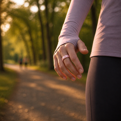 Woman wearing a pink ceramic smart ring on a rainy waterfront fitness walk 