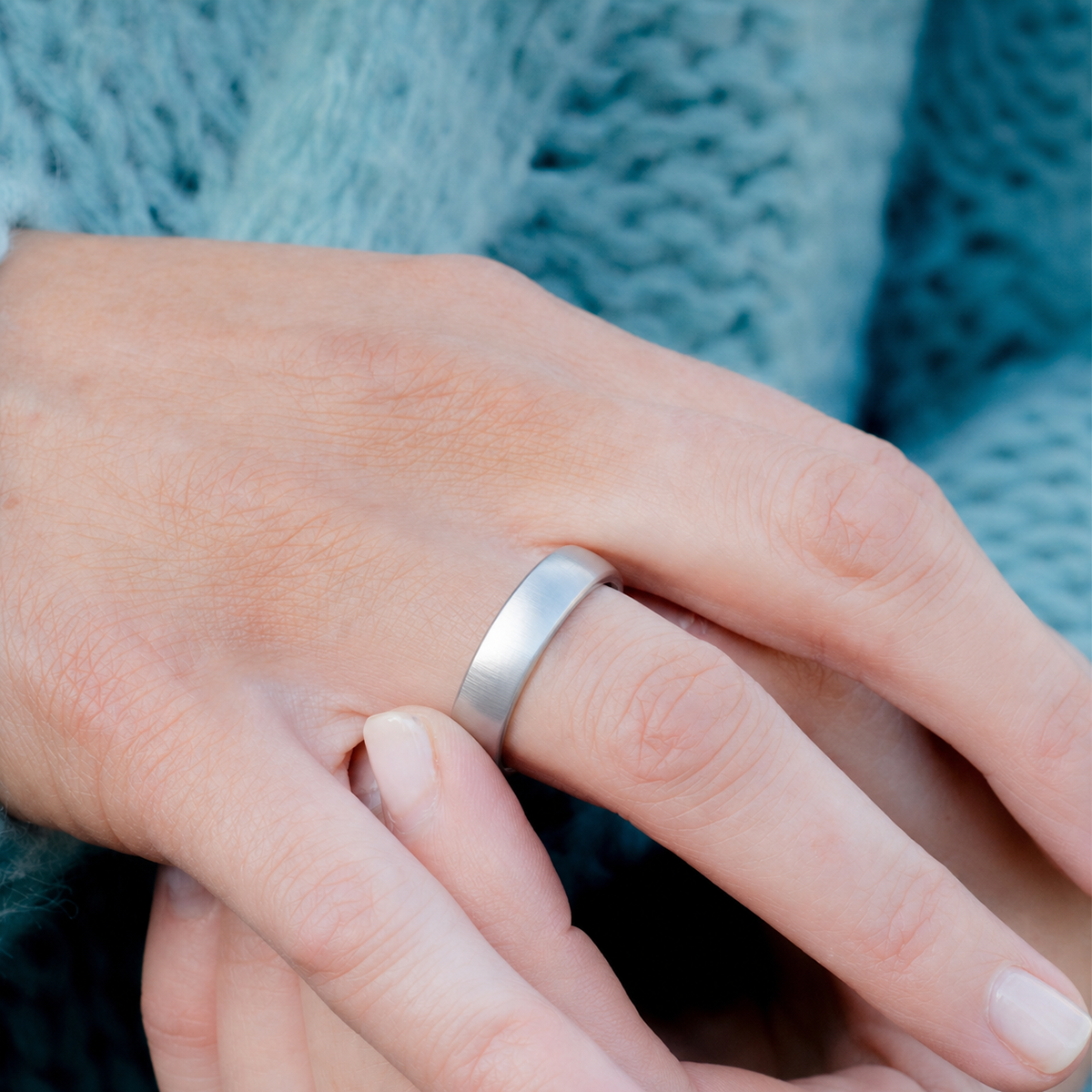 Woman wearing a brushed silver smart ring in a close-up hand detail#color_r10-silver
