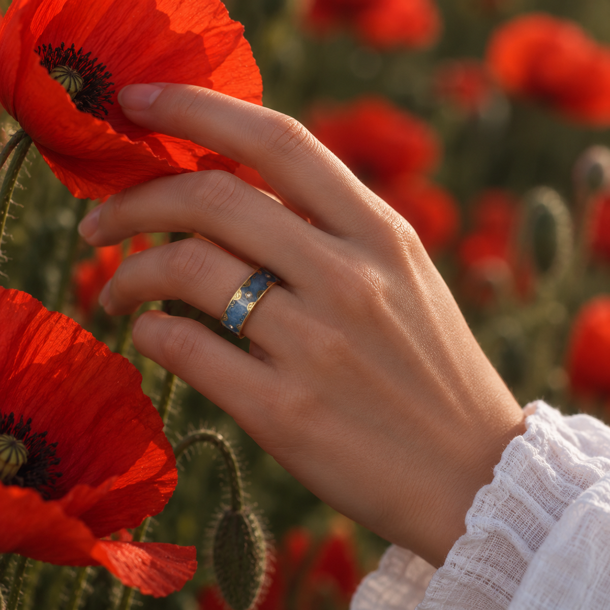 Woman wearing a Retro Blue Smart Ring with gold detailing beside vibrant red flowers#color_retro-blue