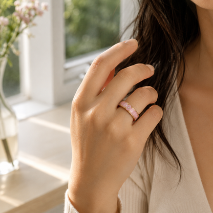 Close-up of a Retro Pink Smart Ring worn on a woman's finger in soft natural window light