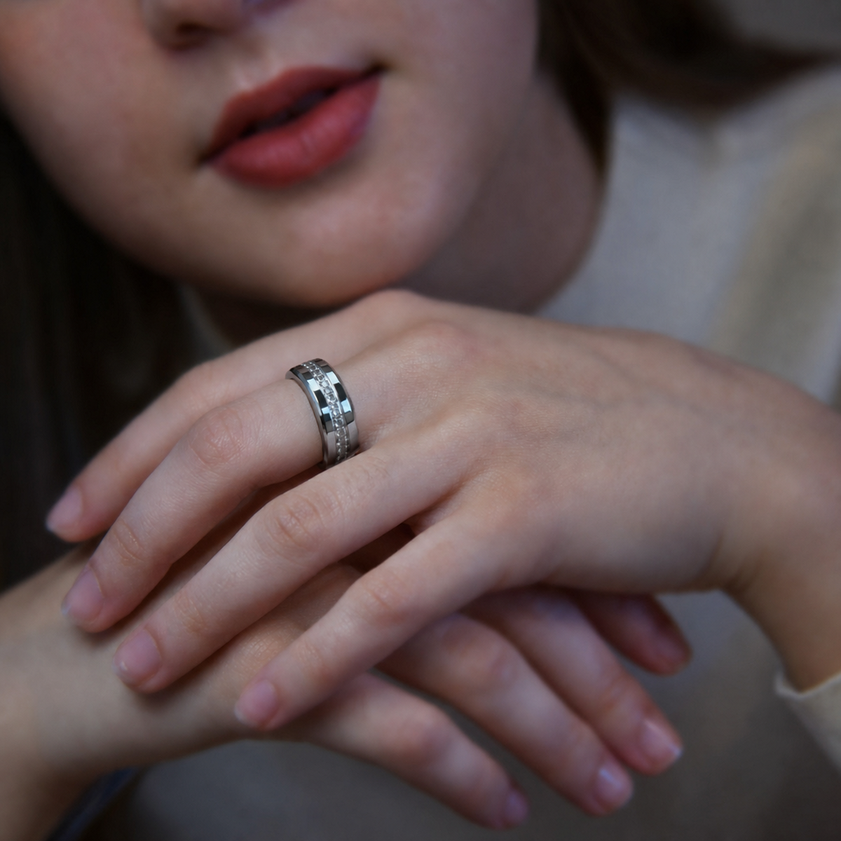 Close-up of a model’s crossed hands showcasing the V6 Silver smart ring against a softly blurred background#color_v6-diamond-silver