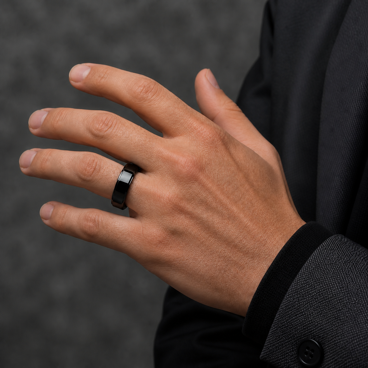 Man wearing a black ceramic smart ring with charcoal tailoring #color_ceramics-black