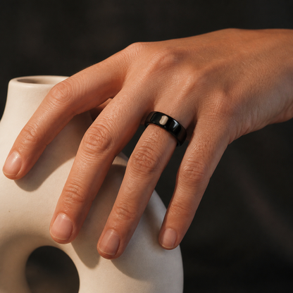 Woman wearing a black ceramic smart ring beside a ceramic vessel #color_ceramics-black