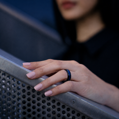 Woman wearing the Wrongduck Galaxy smart ring by a modern railing#color_galaxy