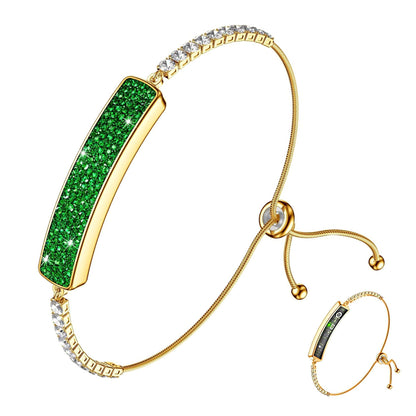 Gold GR1 smart bracelet with green crystal face, clear stone links, and adjustable slider
