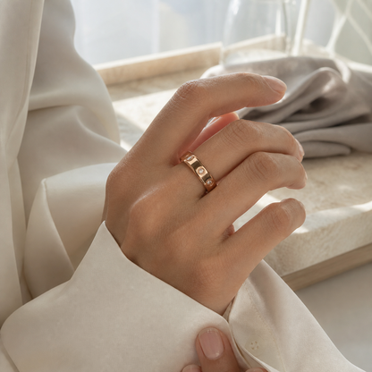 Woman wearing the Wrongduck HR1 rose gold smart ring while adjusting an ivory blouse cuff#color_hr1-rose-gold