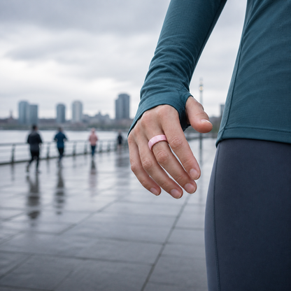 Woman wearing a pink ceramic smart ring on a rainy waterfront fitness walk #color_ceramics-pink