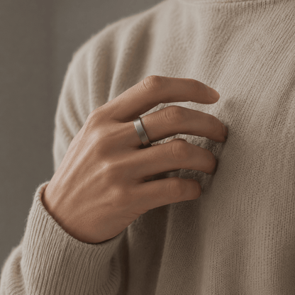 Hand wearing silver R10 ring against beige knit sweater in close-up lifestyle view