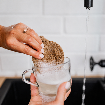 Rose gold SR1 smart ring with water droplets while washing a glass#color_sr1-rose-gold