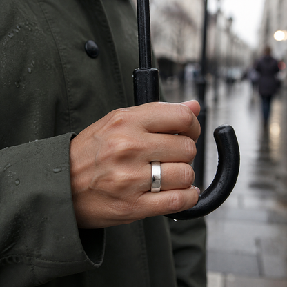 Polished silver SR1 smart ring worn in the rain while holding an umbrella#color_sr1-silver