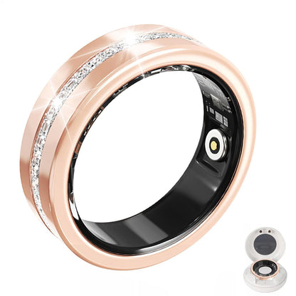 Rose gold V6 diamond smart ring with crystal center band and black sensor lining beside charging case