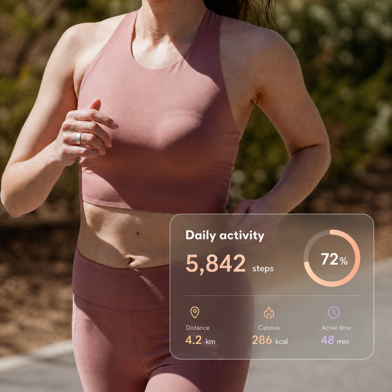 Faceless woman running outdoors while wearing a silver smart ring with an activity-tracking display
